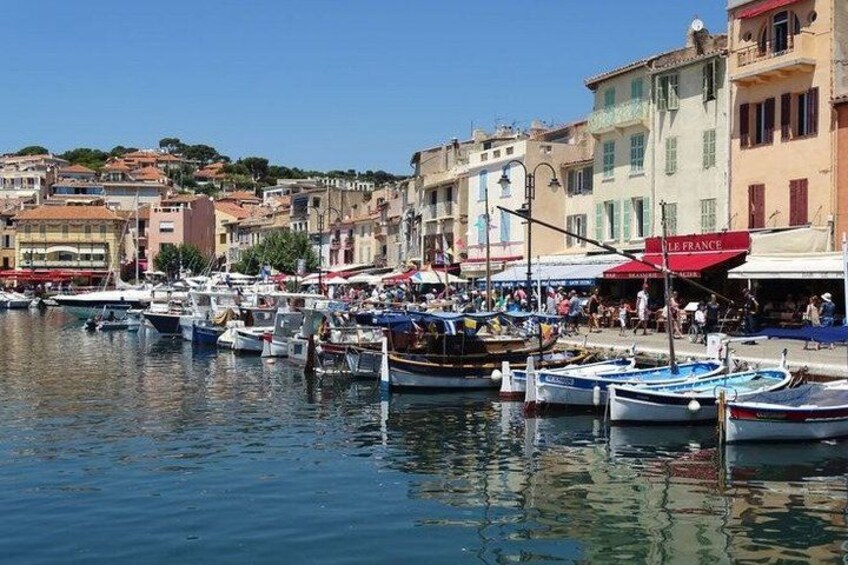 A harbor with boats docked, buildings, and a clear sky. 2