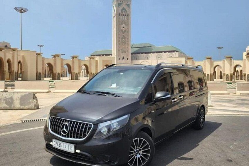 A black Mercedes-Benz SUV parked in front of a mosque with a minaret. 4