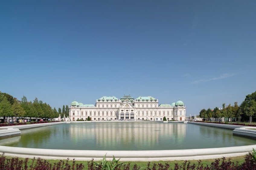 Ein großes, verziertes Gebäude mit einem Wasserspiel vor der Fassade. 2