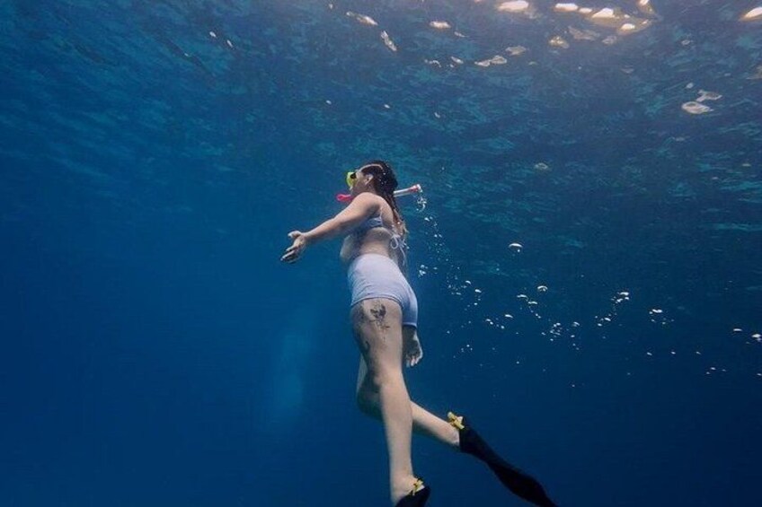 A person swimming underwater. 3