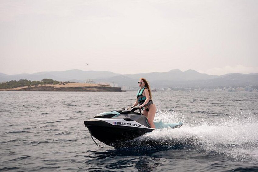 A person jet skiing on a body of water with mountains in the background. 2
