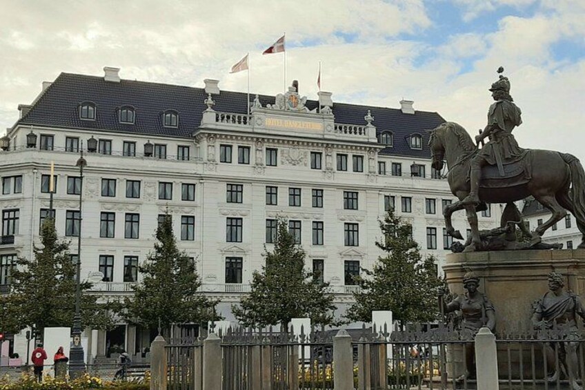 A large white building with a statue of a person on a horse in front. 4