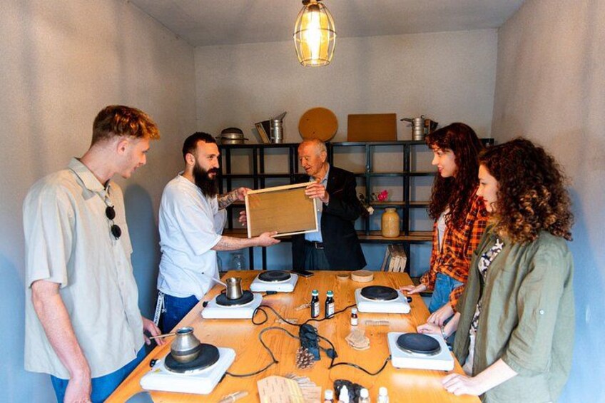 Een groep mensen rond een tafel met elektronische apparatuur, mogelijk voor een workshop of demonstratie. 1