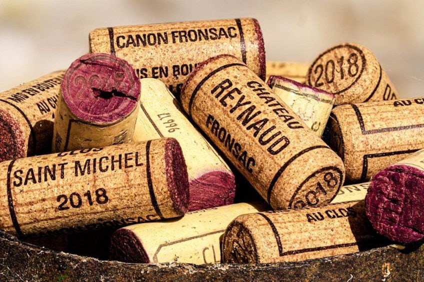 A collection of wine corks with labels such as 'Canon Fronsac' and 'Reynald.' 2