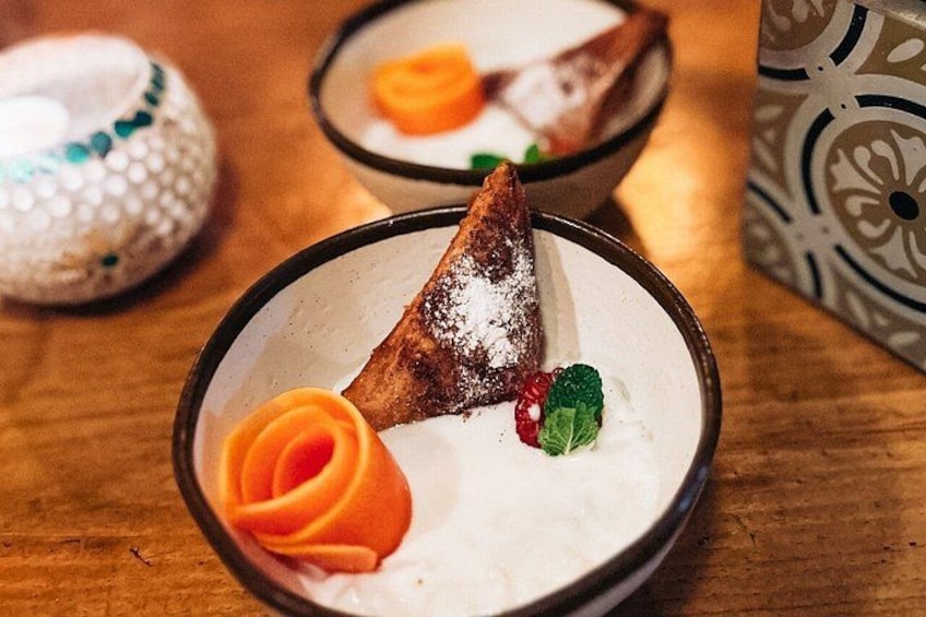 Dessert med en trekantet kage, appelsinpynt og mynteblade på en tallerken. 3