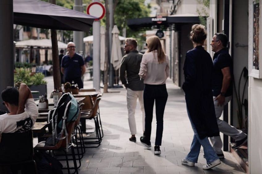 En gade med udendørs siddepladser, gående mennesker og et parkeringsforbud. 5