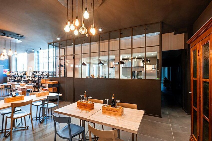 Interior moderno de una cafetería con mesas y sillas de madera, y lámparas colgantes. 3