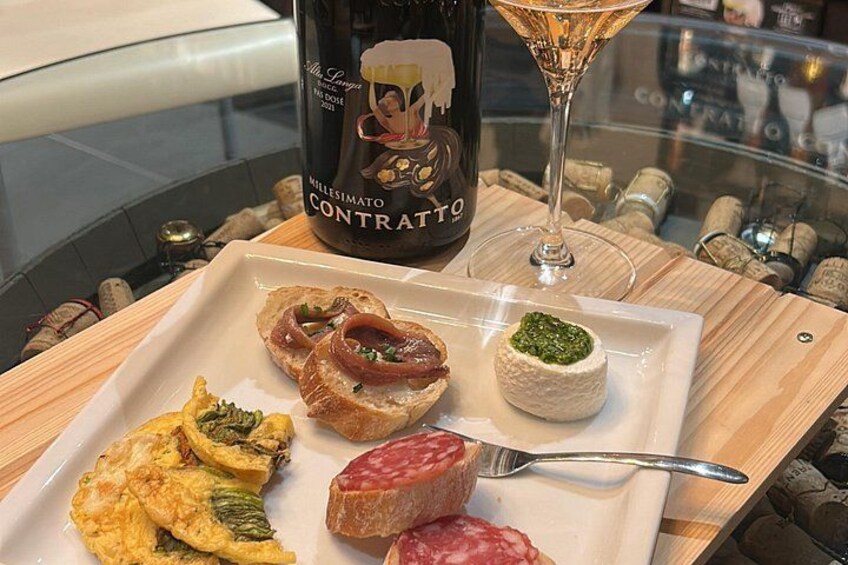 Un plato de comida con una botella de vino y una copa de vino. 1