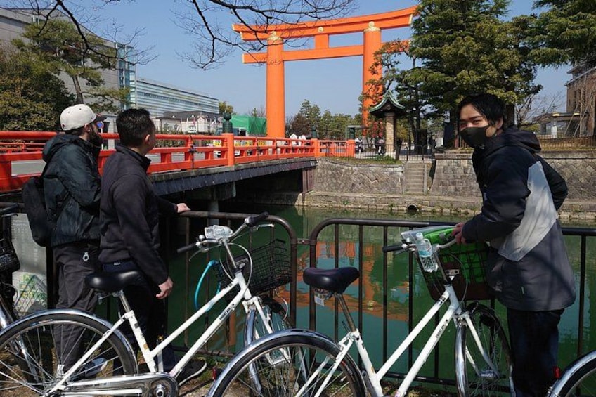 En bro med en rød torii-port, cykler og et vandareal. 4