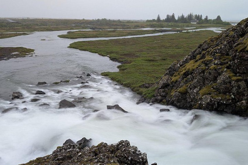 A river flowing through a landscape with rocky terrain and grassy areas. 2