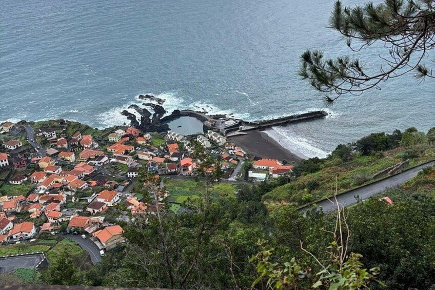 A coastal village with red-roofed houses, a pier, and a rocky coastline. 5