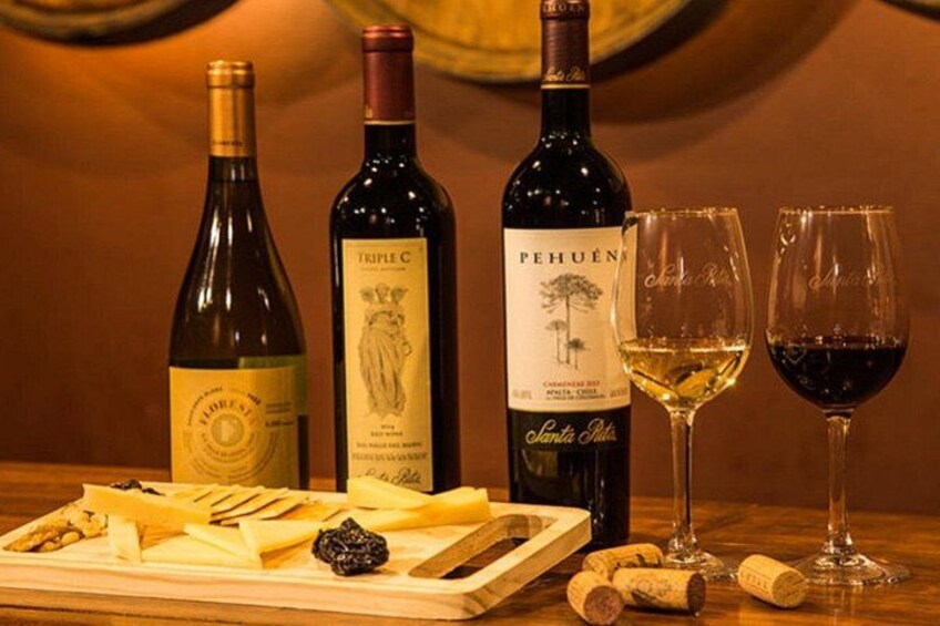 Three wine bottles, two glasses, and a wooden board with cheese and crackers. 5