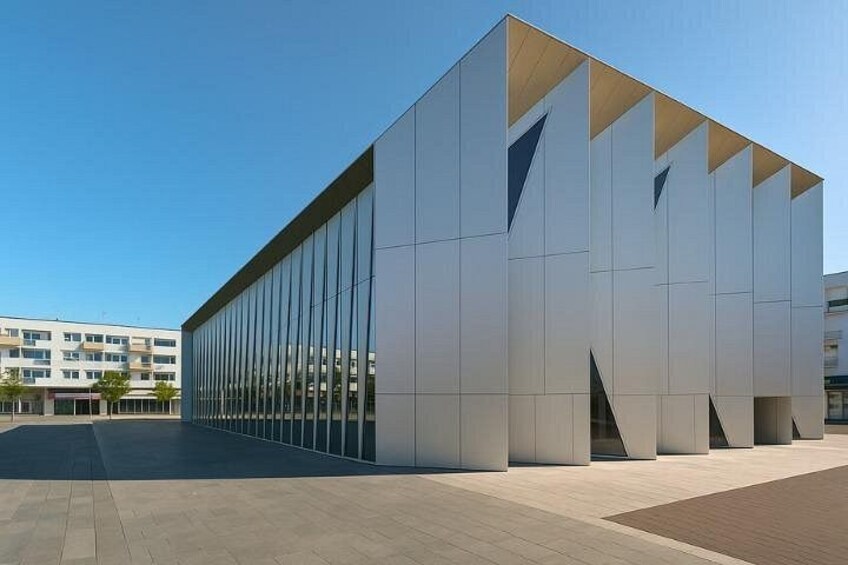 A modern building with reflective glass windows and a geometric design. 3