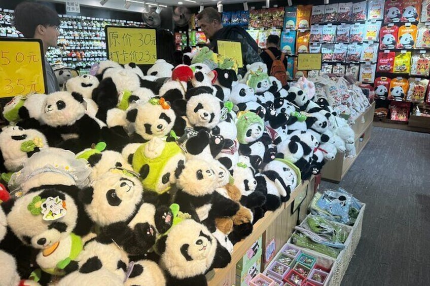 A store aisle with shelves of panda plush toys and various packaged goods. 2