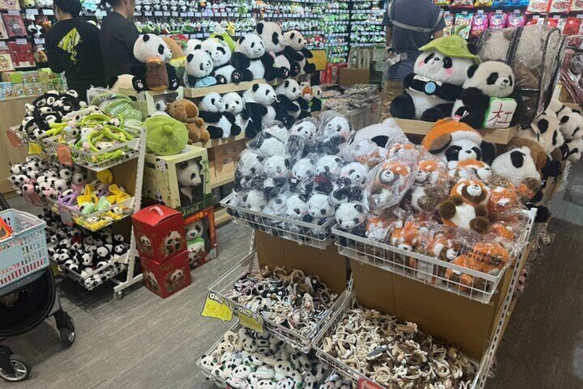 A store aisle with shelves stocked with panda-themed merchandise, including plush toys and bags. 4