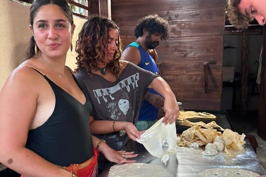 Drie personen bereiden eten in een landelijke keuken. 1