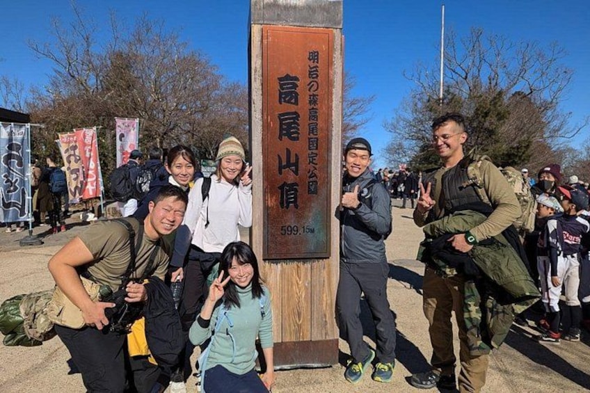 A group of people posing in front of a sign with Japanese characters. 4