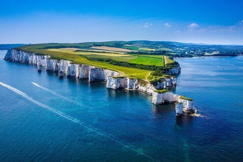 A coastal landscape with white cliffs and a green field. 5