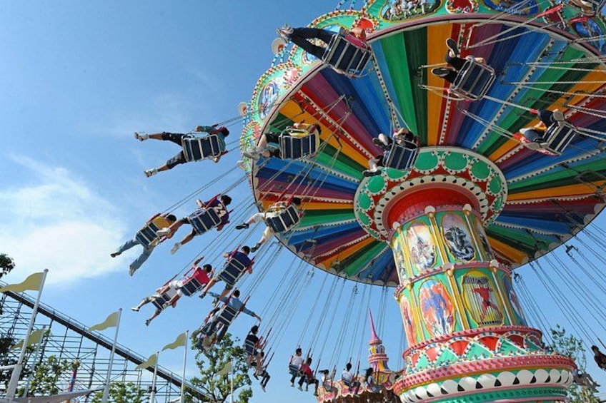 A colorful amusement ride with people seated and swinging. 3