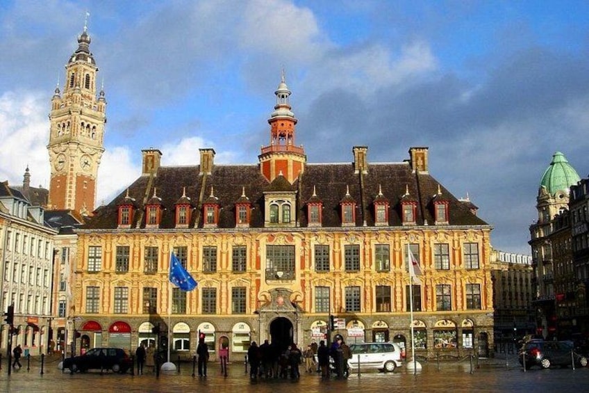A historic building with a clock tower, a prominent dome, and flags. 3