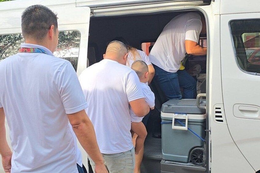 Des personnes montent à bord d’un fourgon blanc dans lequel se trouve une glacière. 2