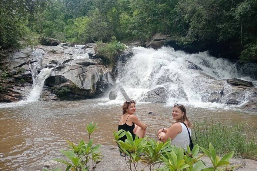 A waterfall with water cascading over rocks, surrounded by greenery. 2