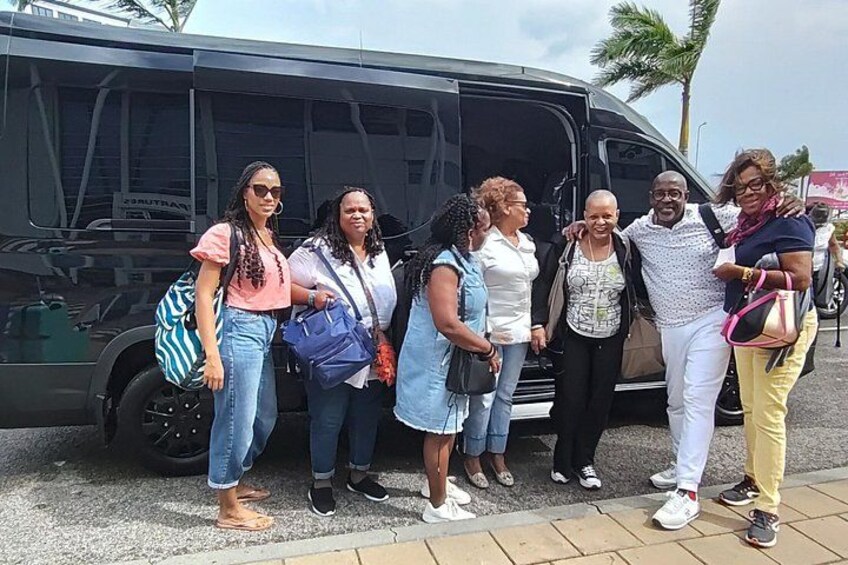 A group of people standing in front of a black van with a sign that reads 'SOUTHTRAN' on it. 5
