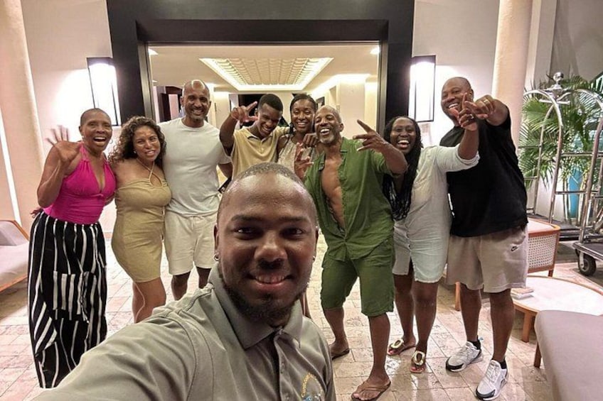 A group of people posing for a photo in an indoor setting with a tiled floor and a doorway in the background. 3