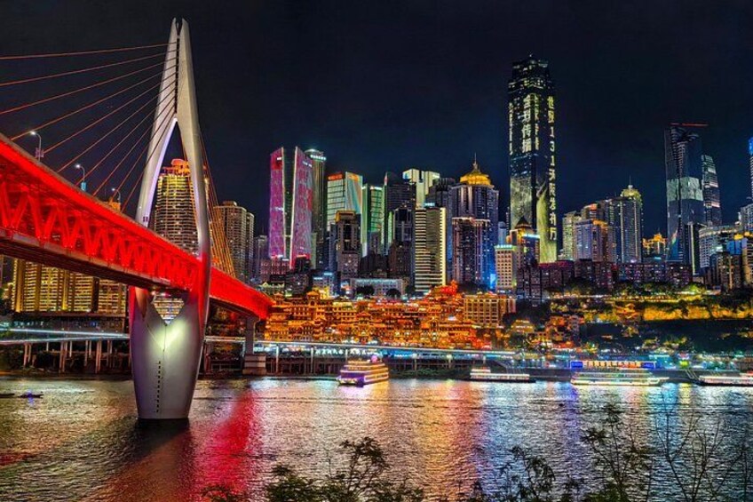 Lo skyline di una città di notte, con un ponte rosso ben visibile in primo piano. 2