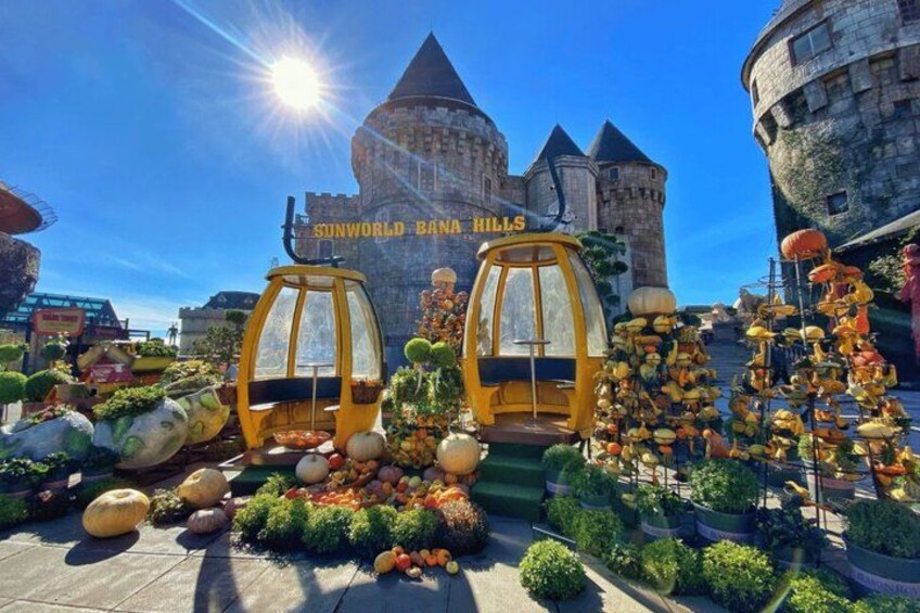A sunny day at SunWorld Banana Hills with a castle-like structure in the background and a yellow cable car in the foreground. 3