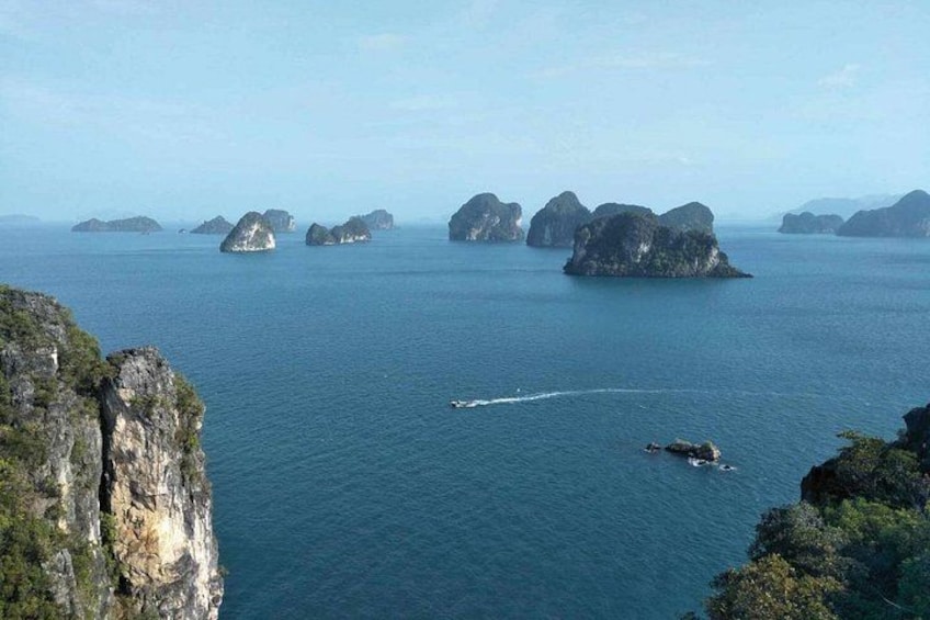 Una embarcación navegando entre grandes islas de piedra caliza en un mar tranquilo. 2