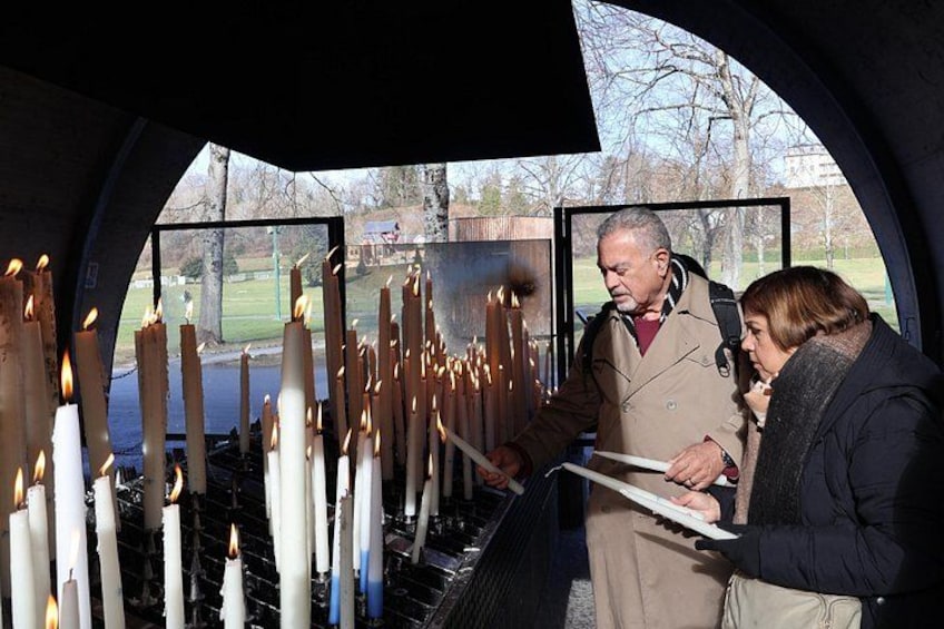A person lighting candles in a ceremonial setting. 2
