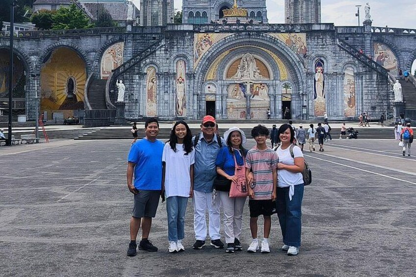 A group of people standing in front of a historic building with arches and detailed mosaics. 3