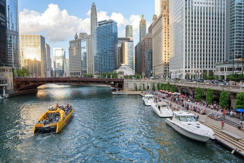 A river with boats, a yellow ferry, and a bridge. 2