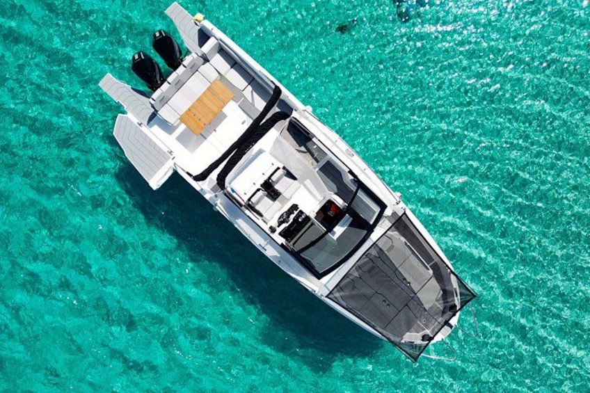 A white boat with a cabin and outboard motor on turquoise water. 2
