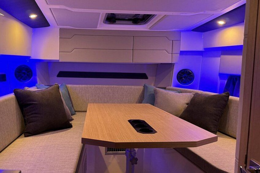 A cozy interior with a wooden table and cushioned seating. 3