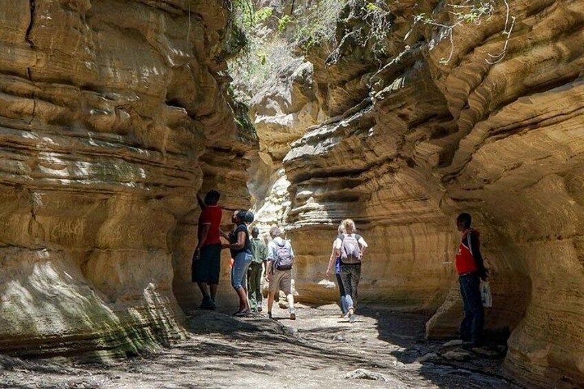 Un groupe de randonneurs traverse un étroit canyon aux parois rocheuses. 5