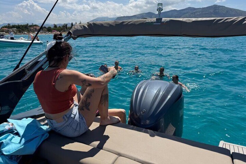 A person on a boat, a water body, and a distant shoreline. 3