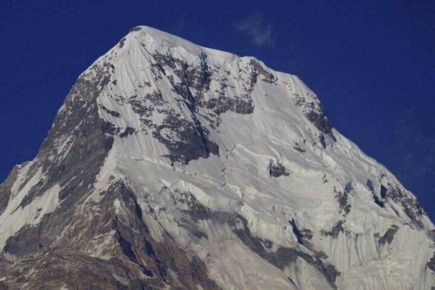 A snow-covered mountain with rugged terrain and clear blue sky. 3