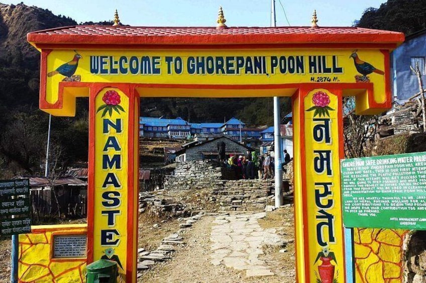 A colorful entrance sign with 'Welcome to Ghorepani Poon Hill' and 'Namaste' written on it. 1