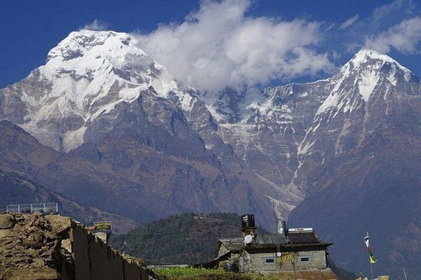 A snow-capped mountain range, a small building with a flag, and a clear sky. 5
