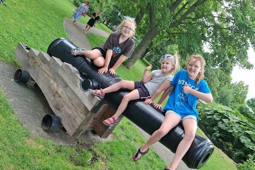 Three people sitting on a wooden structure with tires. 4