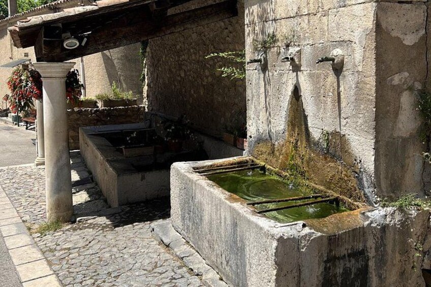 An old stone structure with water channels and a column. 5