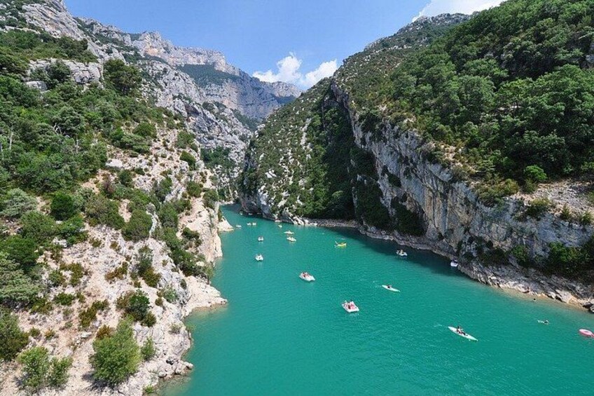 A turquoise river surrounded by rocky cliffs and greenery. 2