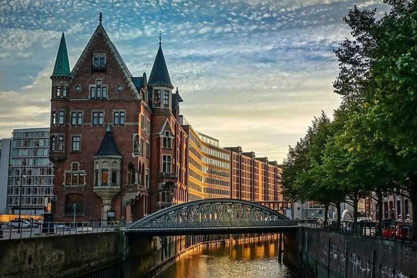 A historic building with a bridge over a canal, surrounded by modern architecture. 1