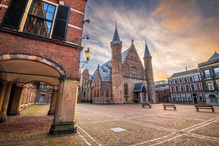 En historisk kirke med to tårne, et brostensbelagt torv og traditionelle bygninger. 3