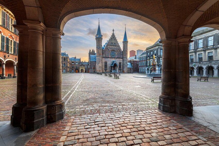 En brostensbelagt plads med en kirke og et tårn i baggrunden. 2