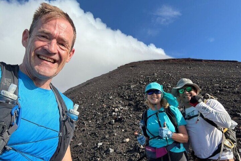 A group of hikers on a volcanic landscape with a clear sky. 1