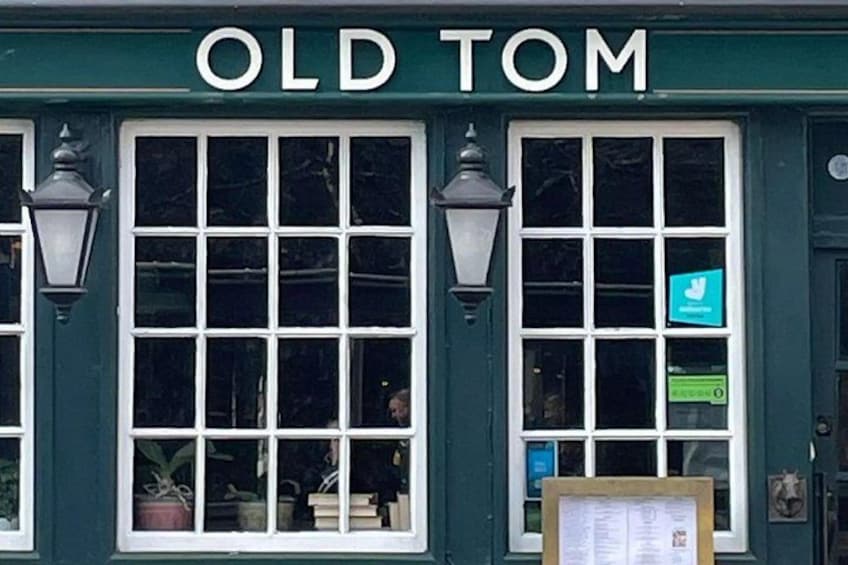 A green building with the sign 'OLD TOM' above the windows. 4
