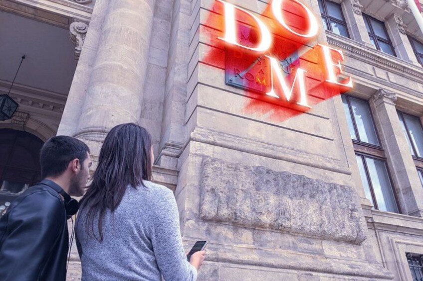 Una coppia in piedi di fronte a un edificio con un grande cartello illuminato che recita 'DOME'. 2